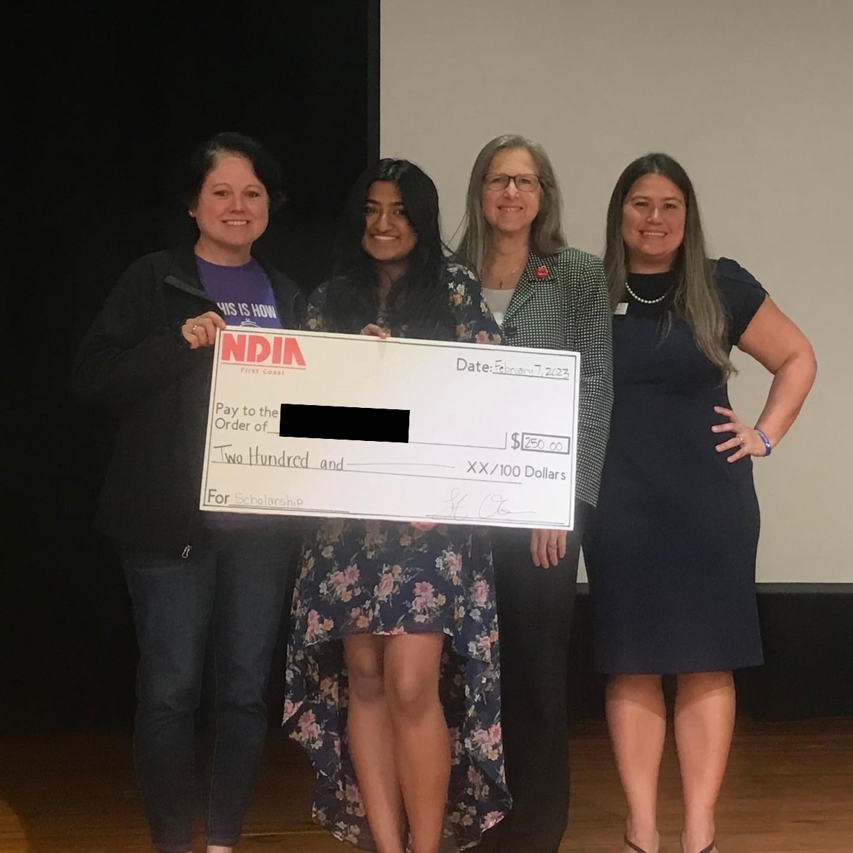 A 2023 recipient of the NDIA First Coast STEM and Vocational scholarship poses with her family
